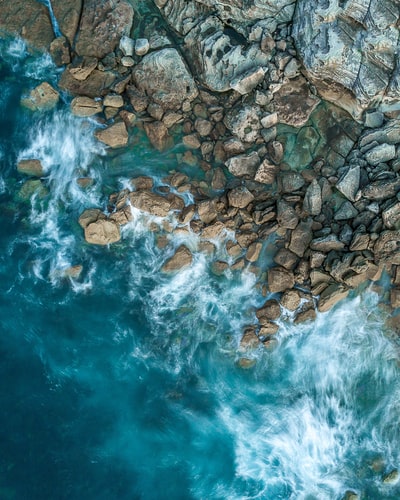白天海洋和岩层的俯视摄影